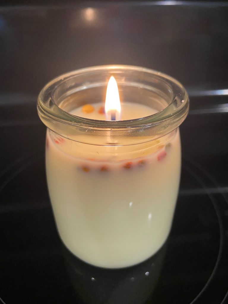 burning candle with flowers in wax